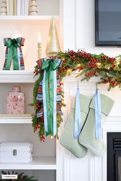 stockings hung on the mantle with christmas decorations