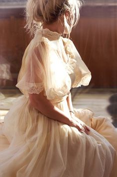 a woman in a white dress is sitting down