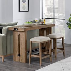 a kitchen table with two stools next to it and a couch in the background