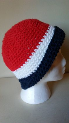 a red, white and blue crocheted hat on a mannequin head