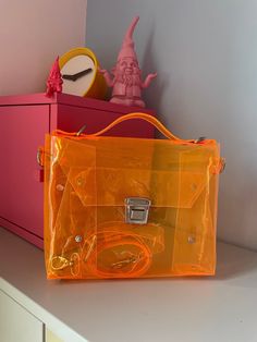 "Stylish Orange Messenger Clasp Crossbody Bag, Shiny Jelly PVC bag, security purse, concert stadium handbag, transparent satchel, vegan Dimensions:  23 x 20 x 5 cm / 10,24 x 7,87 x 1,97 inch strap 2 cm( 0,8 inch)  and regular max 140 cm ( 56 inches) Looking for a trendy and functional crossbody bag? Look no further than our Orange Messenger Clasp Crossbody Bag available on Etsy. With its vibrant orange color and convenient clasp closure, this bag is both fashionable and practical. Our crossbody Security Bag, Pvc Bag, Festival Bag, Day Bag, Messenger Bags, Vibrant Orange, Cleaning Clothes, Running Errands, Phone Numbers