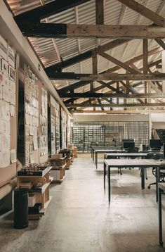 an empty room with tables and boxes on the floor in front of it, surrounded by wooden beams