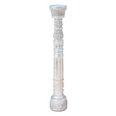 a tall white candle holder sitting on top of a table