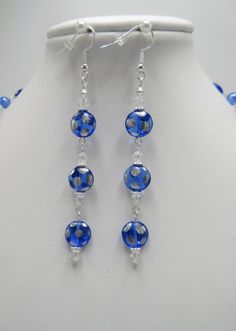 "This necklace set is made with beautiful sapphire Czech glass lentil beads. The flat round beads are covered with silver polka dots and separated with 4mm crystal bicones and 6mm clear blue rounds. The earrings dangle 2.5\" from the loops of the silver plated ear wires. The 7.5 inch bracelet is adjustable to 8.5 inches. This 3 piece set will be slipped into an organza bag and shipped in a bubble mailer." Round Blue Glass Jewelry, Adjustable Blue Czech Glass Jewelry, Silver Beaded Round Jewelry Sets, Blue Polished Beads Round Jewelry, Adjustable Silver Beaded Jewelry Sets, Silver Beaded Jewelry Sets, Blue Faceted Beads Round Jewelry, Blue Jewelry With Polished Round Beads, Blue Polished Round Beads Jewelry