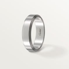 a white gold wedding ring on a plain surface with the word canon engraved in it