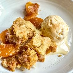 a white plate topped with ice cream and an orange slice covered in crumbs