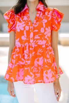 This blouse is so worth your while! It's absolutely adorable! That bold floral print is absolutely precious! We know you are going to love that button down fit as well! Especially since it can be paired with everything form sandals to heels! Collared neckline Button down front closure Ruffled cap sleeves Floral print No stretch Savannah is wearing the small. Spring Bold Print Orange Tops, Orange Bold Print Summer Top, Summer Orange Tops With Bold Print, Spring Short Sleeve Blouse With Bold Print, Orange Tops With Bold Print For Summer, Chic Summer Blouse With Vibrant Print, Summer Blouse With Bold Print, Orange Blouse With Vibrant Print For Spring, Chic Orange Floral Print Blouse