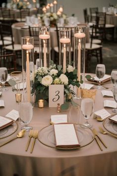 the table is set with candles, plates and menus for an elegant wedding reception