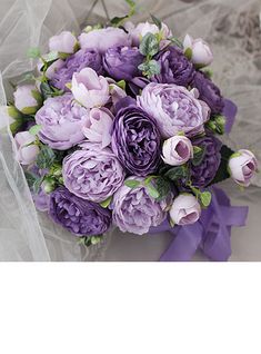 a bouquet of purple flowers sitting on top of a bed