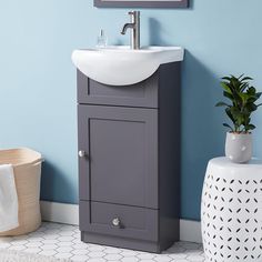 a bathroom with blue walls and a white sink in the corner next to a plant