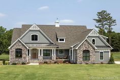 a large house with stone and shingles in the front yard