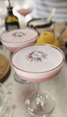 two pink drinks sitting on top of a table