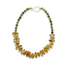 I love the combination of size, texture, and color in the "Abundance Beacon" necklace. This piece is anchored by golden yellow citrine nuggets and finished with green round chrysoprase beads. It has a striking, tropical summer kind of vibe.Citrine is thought to attract wealth and prosperity, not just in financial terms but also in a richness of ideas and opportunities. Chrysoprase is thought to promote emotional balance, joy, and unity – essential qualities for leading a successful and harmoniou Green Citrine Jewelry With Natural Stones, Luxury Yellow Necklaces With Round Beads, Artisan Yellow Gemstone Beads Necklace, Luxury Yellow Round Beaded Necklaces, Luxury Green Chrysoprase Necklace, Financial Terms, Attract Wealth And Prosperity, Unique Hand-strung Yellow Necklace, Chrysoprase Necklace