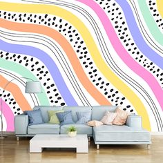 a living room with a couch and colorful wallpaper