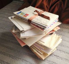 a stack of mail sitting on top of a bed