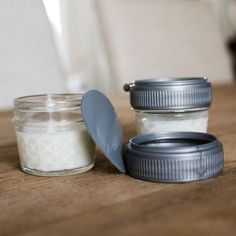 there are two jars on the table next to each other and one has a spoon in it