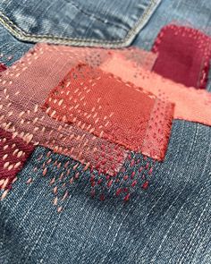 the back side of a pair of jeans with different colored stitchs and holes in them