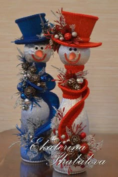 two snowmen wearing hats and scarves on top of each other