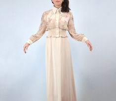 Keep cool and collected in this classic vintage 1970s cream maxi dress with a sheer floral print matching jacket.  ✈ Features ✈ J a c k e t . . . * Collared neckline * 7 faux pearl buttons  * Sheer floral print body w/ rhinestone detailing * Solid cuffs w/ 2 faux pearl buttons (non-working) & hidden metal snaps * Wide elasticized ruched bottom hem D r e s s . . . * Short standup collar * Empire waistline * A-line lower ✈ Specifics ✈ Label: -- Tagged Size: -- Approx. Fit: Extra Small to Small Col Elegant Spring Maxi Dress For Vintage Fashion, 1970s Style Spring Evening Maxi Dress, Vintage Formal Maxi Dress For Fall, 1970s Fitted Maxi Dress For Daywear, Vintage Spring Maxi Dress For Weddings, Vintage Maxi Dress For Dress Down In Spring, Vintage Style Maxi Dress For Spring Wedding, 1970s Fitted Maxi Dress, Formal Vintage Maxi Dress For Fall