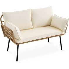 a wicker couch with two pillows on top of it and one arm resting against the back