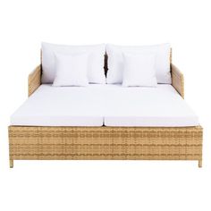 a wicker bed with two pillows on it