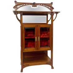 an ornate wooden cabinet with glass doors and mirror on top, against a white background