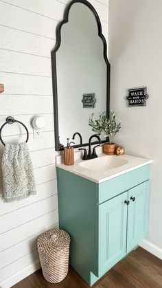 a bathroom with a sink, mirror and towel rack on the wall next to it