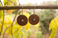 Meditatively hand stamped pure copper discs dangle from hand formed sterling silver ear hooks with a hand formed sterling silver center. Total length is 1 3/4 inches. Rustic and rhythmically styled showing the unique quality of a handmade original. A patina has been added bring depth to the stamped design and add to the rustic style.. I find these have a nice thickness to them and a good weight- each earring weights approximately .10 oz (3g) Adjustable Stamped Dangle Earrings, Nature-inspired Round Brass Earrings, Earthy Copper Jewelry For Festivals, Bohemian Stamped Brass Jewelry, Bohemian Brass Stamped Jewelry, Earthy Soldered Earrings For Gift, Bohemian Hammered Earrings For Festivals, Nickel-free Copper Earrings For Festival, Bohemian Etched Brass Earrings