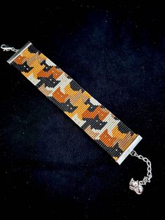 a bracelet with an orange and black camo pattern is shown on a black background