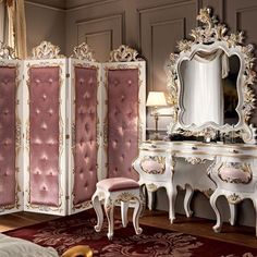 an ornately decorated bedroom with pink and white furniture, gold trimmings and mirrors