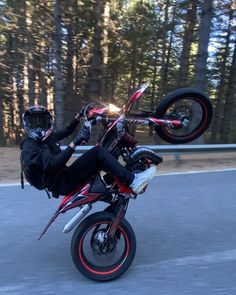 a man riding on the back of a red motorcycle