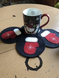 a coffee cup sitting on top of a table next to two mickey mouse coasters