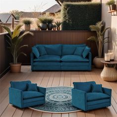 a living room with blue couches and chairs on the wooden floor next to potted plants