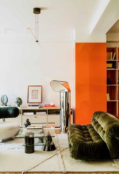 a living room filled with furniture and orange walls