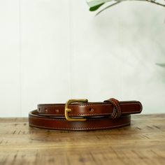 If you are looking for a narrow stylish women's belt that will actually last you a lifetime, then this is the belt for you! So many women's belts focus on looks over durability, but we accomplished both. Made from Premium English Bridle leather, this belt is the best of the best. We used a rounded brass buckle and added a unique crossover stitched keeper, both held on with secure black snaps to easily switch buckles on a whim. Pair the Dixie with your favorite pair of slacks or jeans for an elev English Bridle, Women's Belts, Women's Belt, Best Of The Best, Brass Buckle, Belts For Women, Leather Belt, Stylish Women, Crossover