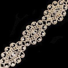 an elaborately designed bracelet with crystal stones on it's side, in gold and white