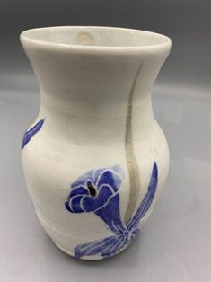 a white vase with blue flowers painted on it