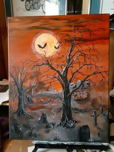 an easel with a painting on it in the shape of a tree and graveyard