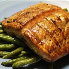 a piece of salmon and green beans on a blue plate