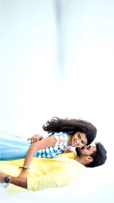 a man and woman laying on top of each other in front of a white background