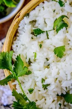 white rice with cilantro and parsley in a wooden bowl on a table