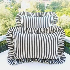 two black and white striped pillows sitting on top of a table