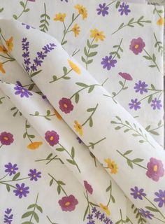 a white sheet with purple and yellow flowers on it