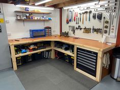 a workbench with lots of tools on the wall and shelves full of tools