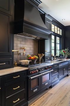 a large kitchen with black cabinets and stainless steel appliances