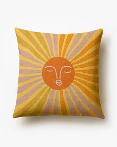 an orange and yellow pillow with a face drawn on it