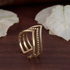 "Triple chevron ring, crown ring, boho ring, wishbone ring, gift for her, gift for mom, curve band, thumb ring, triple v ring, knuckle ring.   ❥ A chevron is an inverted V-shaped pattern. The word is usually used in reference to a kind of fret in architecture, or to a badge or insignia used in military or police uniforms to indicate rank or length of service, or in heraldry and the designs of flags.  ❥ The brass metal will develop a nice antique color over time. So, I suggest cleaning it once in a while to get back to the shiny original color. You can use natural ingredients like lemon or vinegar with water to clean it. Also, apply a thin coat of transparent nail paint/enamel on the ring's inner side to save it from tarnishing. All our products are Nickel and Lead-free & tarnish-resistant. V Shaped Ring, Rudraksha Bracelet, Ring Crown, V Ring, Wishbone Ring, Gold Jewellry, Brass Rings, Gold Chevron, Police Uniforms