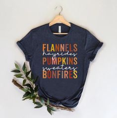 Flannels Pumpkins Bonfires T-Shirt, Fall Season Shirt, Autumn Outfit, Pumpkin Lover Gift Shirt, Thanksgiving Family Shirt, Thankful Gift HOW TO ORDER 1-) Please, check and review all the photos. 2-) Choose your t-shirt size and color. *Different styles of shirts may have different shades of the same color choice due to different manufacturer brands. *For this reason, we recommend matching shirts from the same styles if you want precisely matching colors (ex. Unisex, V-necks, Toddler, etc.). 3-) Casual Fall T-shirt With Name Print, Casual Name Print T-shirt For Fall, Fall Crew Neck T-shirt With Name Print, Blue Letter Print T-shirt For Fall, Blue Pre-shrunk T-shirt For Fall, Shirt Autumn Outfit, Thanksgiving Shirts For Women, Thankful Pumpkin, Cute Fall Shirt