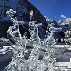 a boat made out of ice sitting on top of snow covered ground with mountains in the background