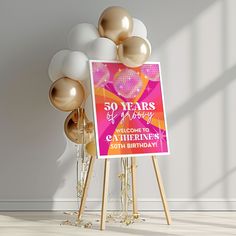 a pink and gold 50th birthday sign next to balloons